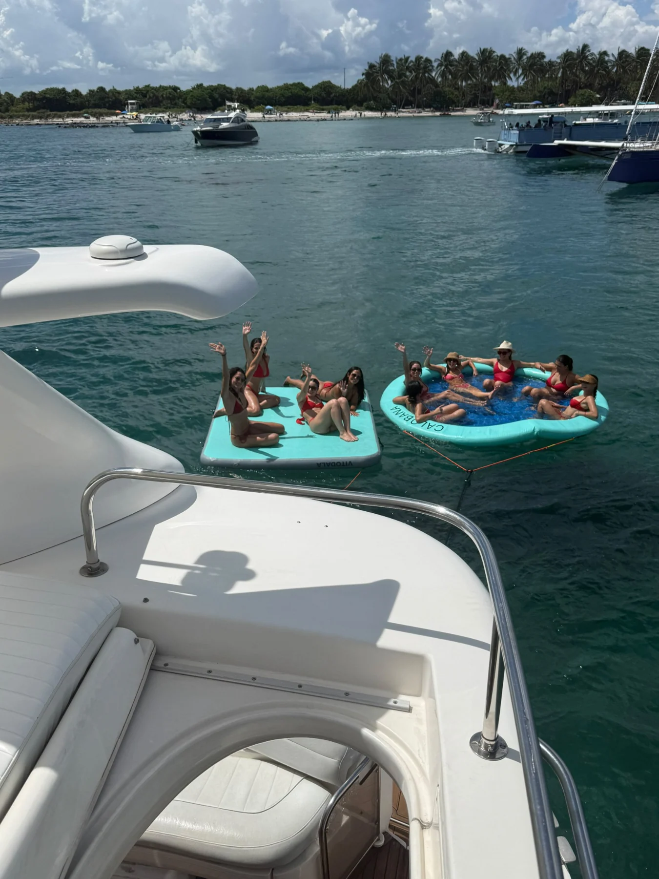 Guests enjoying floats alongside a yacht