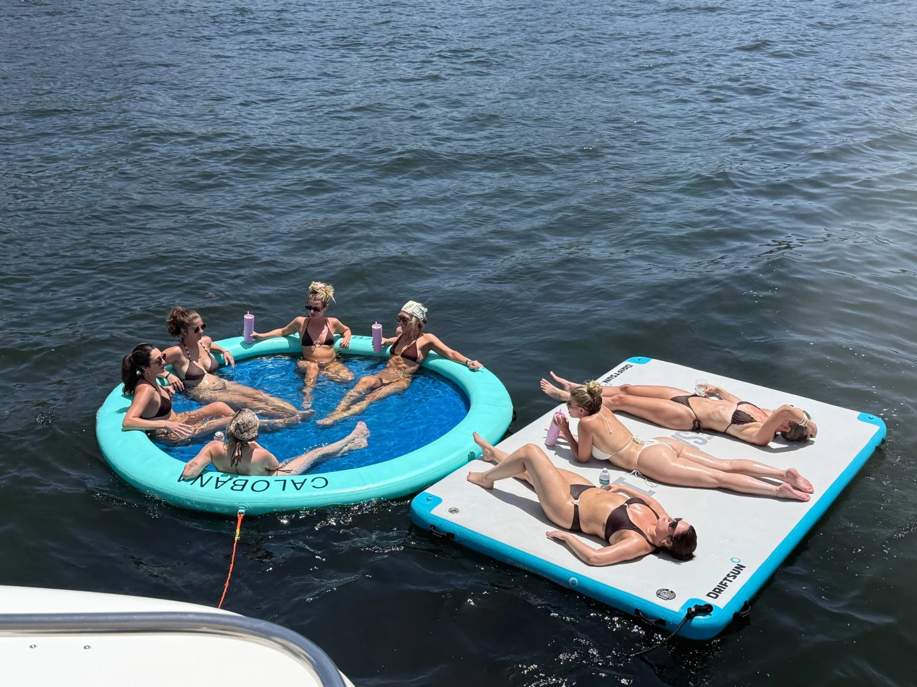 Friends on a floating mat and an inflatable ring