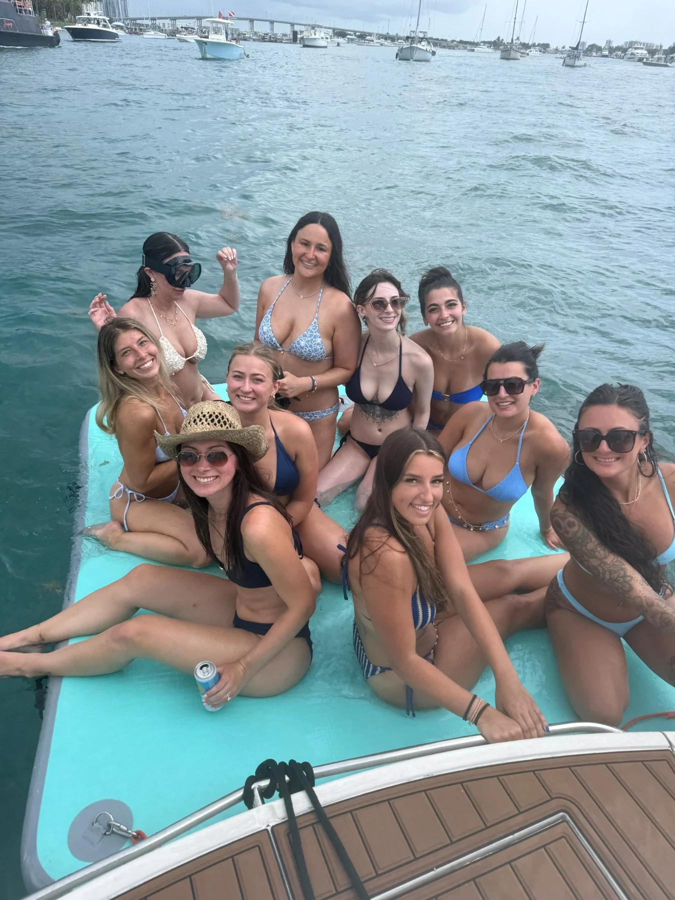 Guests sharing a floating mat next to the yacht