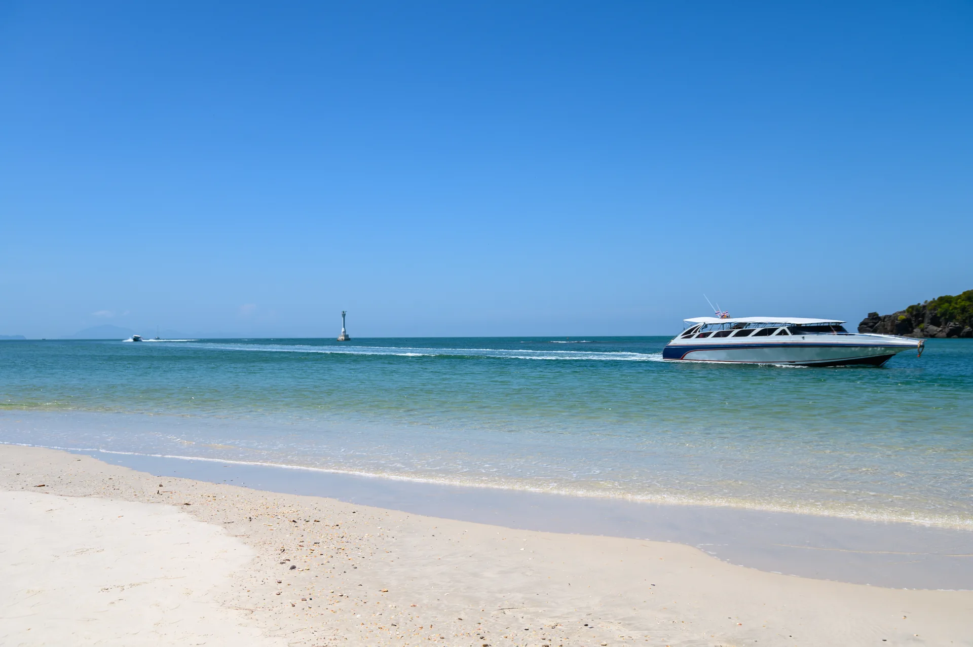 A white yacht on clear blue water near the shore